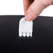 a finger holding a white object