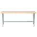 An Advance Tabco wood work table with metal legs.