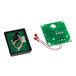 A green circuit board with white and red wires.