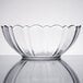 An Arcoroc clear glass bowl with a scalloped edge.