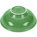 A close-up of a green Fiesta pedestal serving bowl with a white rim.