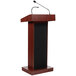 A mahogany wooden Oklahoma Sound lectern with a wireless handheld microphone on top.