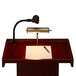 An Oklahoma Sound mahogany orator lectern with a microphone and a pen.