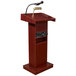 An Oklahoma Sound mahogany podium with a microphone and speakers.