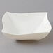 A white bowl with a curved edge on a gray background.