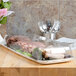 A clear plastic Sabert catering tray with meat and vegetables on a table.