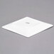 A CAC white porcelain coupe dinner plate with a small square on top.