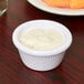 A white Carlisle fluted melamine ramekin filled with white sauce.