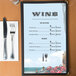 Menu paper with a white background and a seafood themed design featuring a crab and a wine glass.
