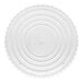 A white Wilton round cake separator plate with a scalloped edge.