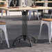 A black Art Marble Furniture standard height table base on an outdoor patio table with a black top.