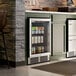 A stainless steel beverage cooler with a glass door built into a kitchen cabinet.