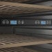 A dual temperature commercial wine cooler with digital controls and wooden shelves.