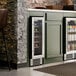 A stainless steel and glass door commercial wine cooler built into a kitchen cabinet.