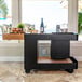 A black Astella outdoor mobile bar with wine on it.