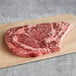 A raw Warrington Farm Meats bone-in ribeye steak on a cutting board.