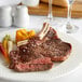 A plate with a Warrington Farm Meats bone-in ribeye steak and vegetables.