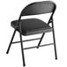 A black Lancaster Table & Seating folding chair with a black padded seat.