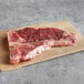 A Warrington Farm Meats T-Bone steak on a brown surface.