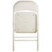 A beige folding chair with a padded seat and back.