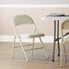 A close-up of a beige fabric folding chair next to a table.