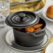 A Vollrath pre-seasoned cast iron pot with potatoes in it.