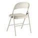 A beige vinyl folding chair with a padded seat and metal frame.