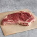 A piece of raw meat on brown paper.