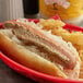 A Pilsudski horseradish mustard topped hot dog with a bun and fries in a basket.