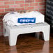 A white plastic bag of potatoes on a Cambro slotted top dunnage rack.