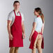 A man and woman wearing red Choice aprons standing next to each other.