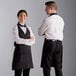 A man and woman wearing Choice black tuxedo aprons.