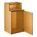 A wooden waste receptacle enclosure with a drop hole, tray shelf, and an open cabinet door.