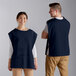 A man and woman wearing navy blue poly-cotton cobbler aprons.