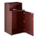 A mahogany waste receptacle enclosure with a drop hole, tray shelf, and an open cabinet door.