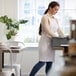 A woman in a white Choice apron in a professional kitchen.