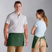 A man and woman wearing Choice hunter green aprons.