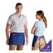 A man and woman wearing Choice royal blue standard waist aprons with pockets.