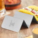 A taco in a Vollrath stainless steel holder on a table.