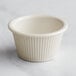 A close up of a white Carlisle fluted ramekin with a white rim.