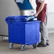 a person putting a bucket into a blue bin