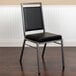 A black Flash Furniture banquet chair with a silver metal frame.