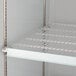 A white coated wire shelf for an Avantco refrigerator.