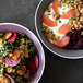 Two Libbey Englewood salad bowls filled with salad and fruit on a table.