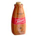 A close-up of a Torani Puremade Pumpkin Pie Flavoring Sauce bottle with a red label.