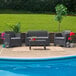 A dark gray Flash Furniture patio set with a table and chairs on a patio with a plant on the table.