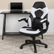 A white Flash Furniture office chair with flip-up arms at a desk with a black and white keyboard.