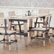 A Lancaster Table & Seating wooden trestle table base with chairs and glasses on a table.