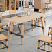 A Lancaster Table & Seating wooden table base with black metal legs.