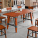A Lancaster Table & Seating trestle table base with a wood and metal leg.